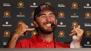 max homa holds shaka hand signs up at the Presidents Cup victory press conference in red shirt