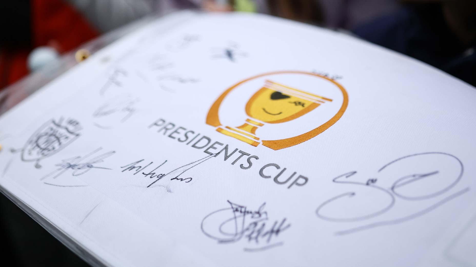 Fans get signatures on flag during a practice round prior to the 2024 Presidents Cup at The Royal Montreal Golf Club.