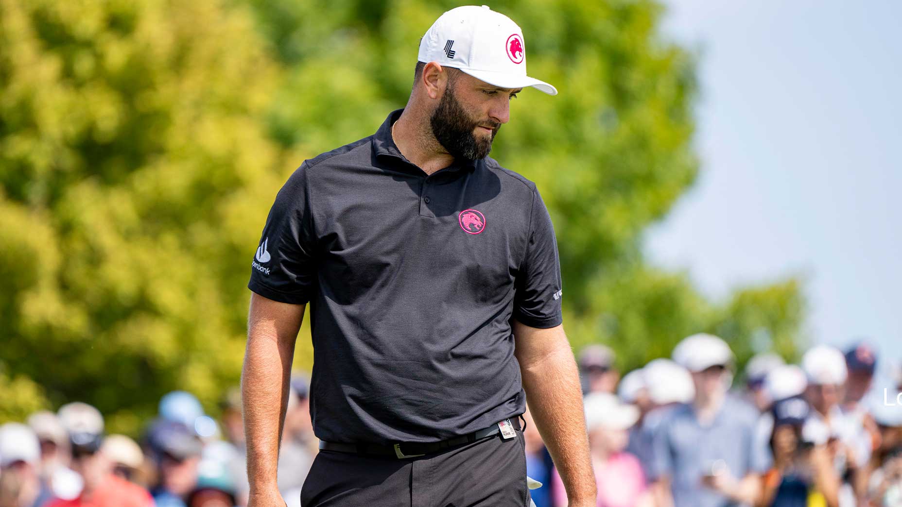 jon rahm stares into the distance at LIV chicago in black shirt and white hat