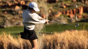 A golfer finishes a swing