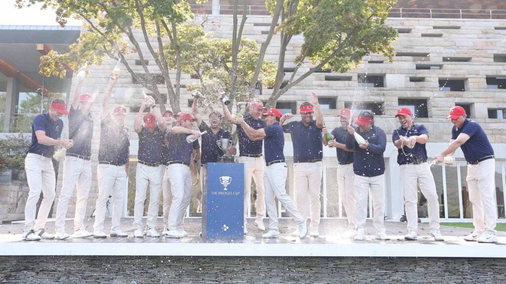 The U.S. Bridges Cup team sprays champagne around the trophy.