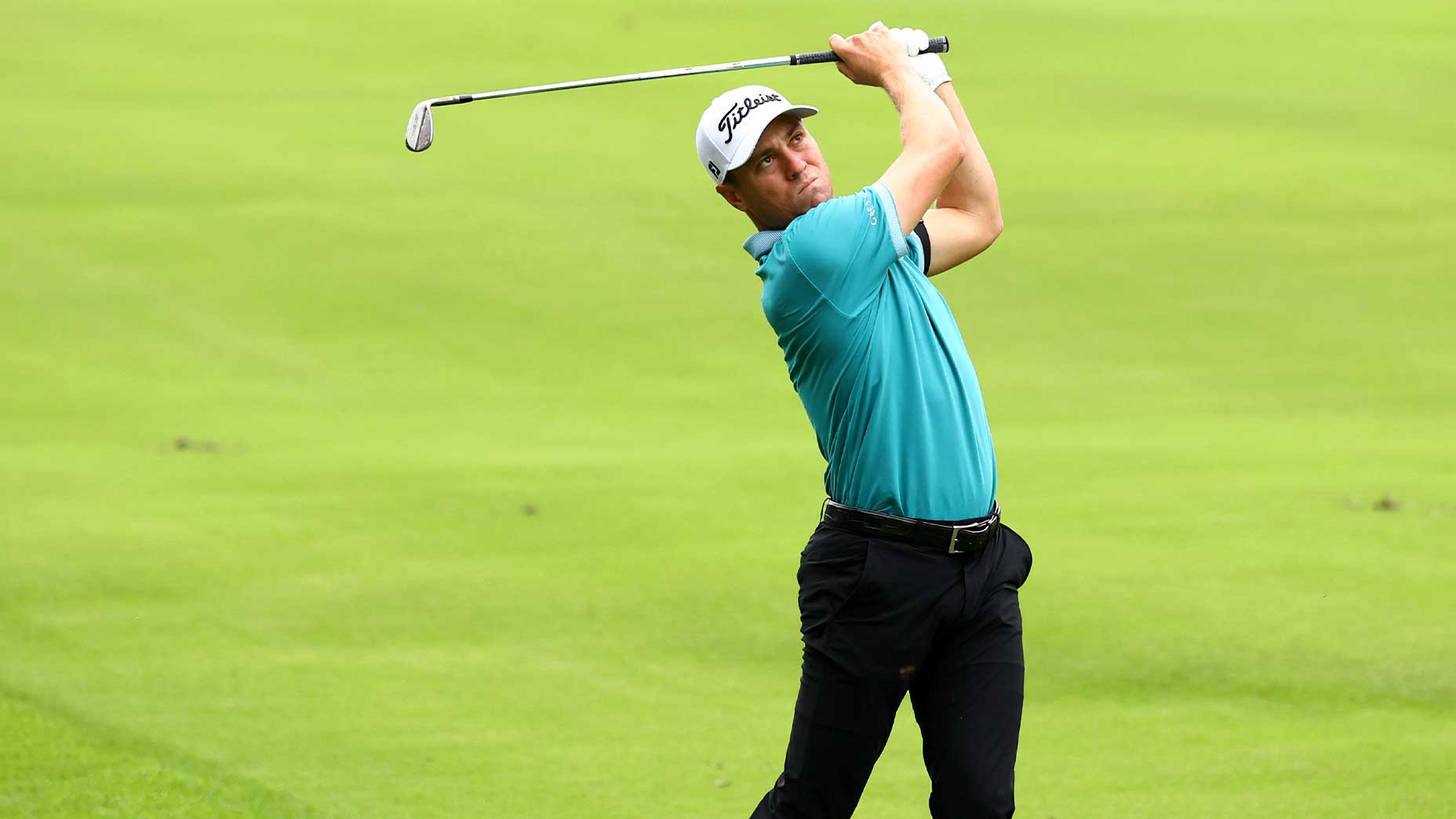 Justin Thomas swings the racket at the Zozo Championship in a green shirt