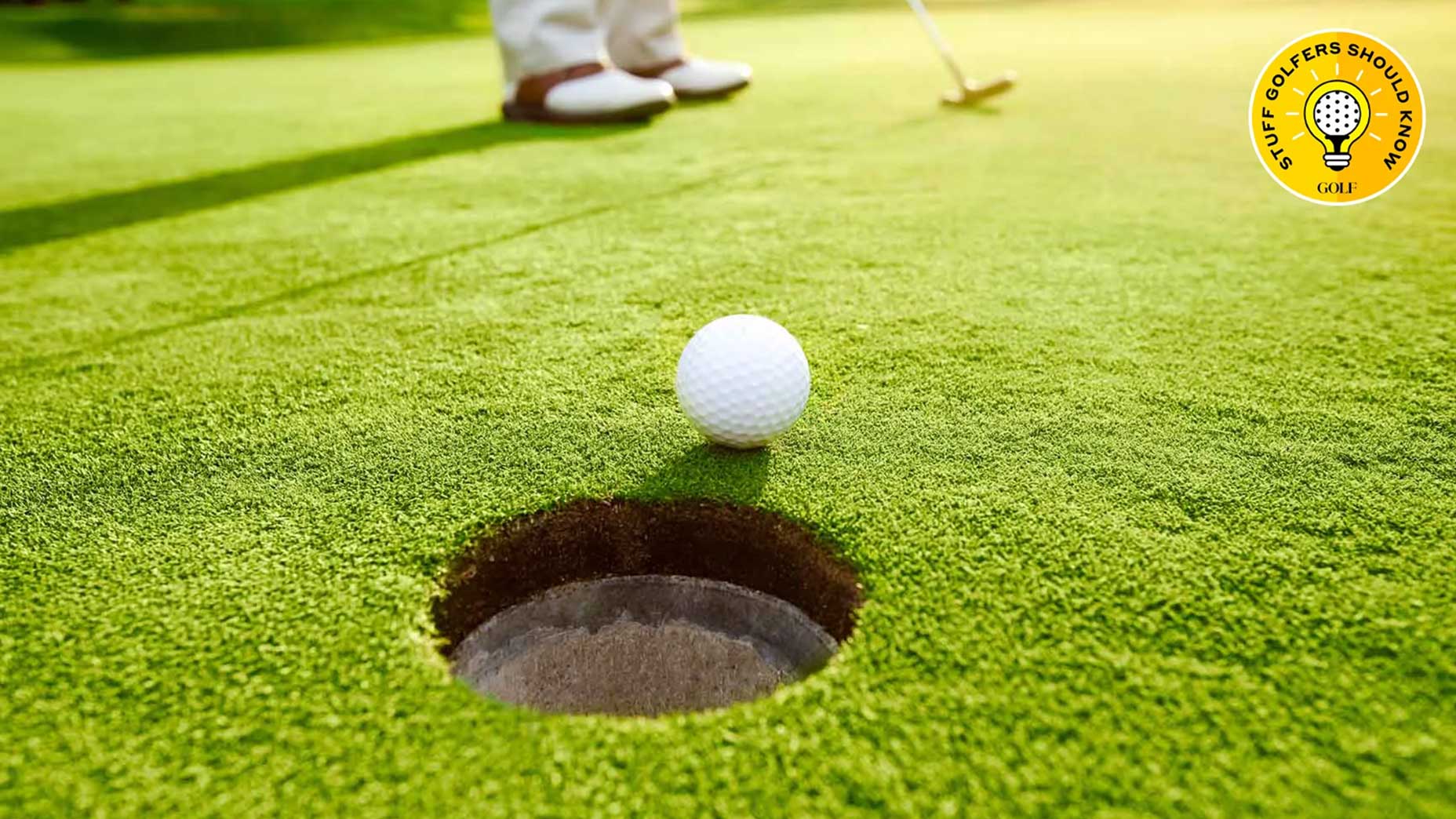 a ball rolls into the hole on a green