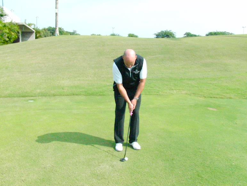 The setup for a short game shot with the putter back