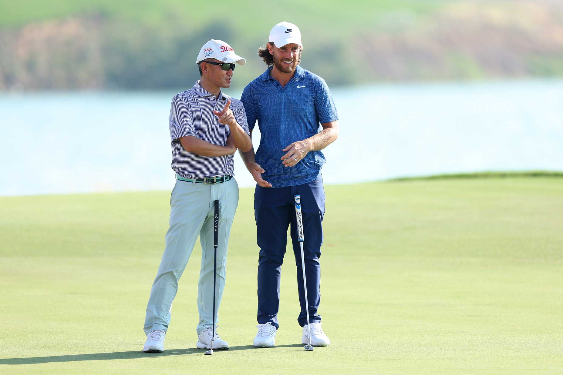 Tommy Fleetwood talks to a partner at the Abu Dhabi HSBC Championship.