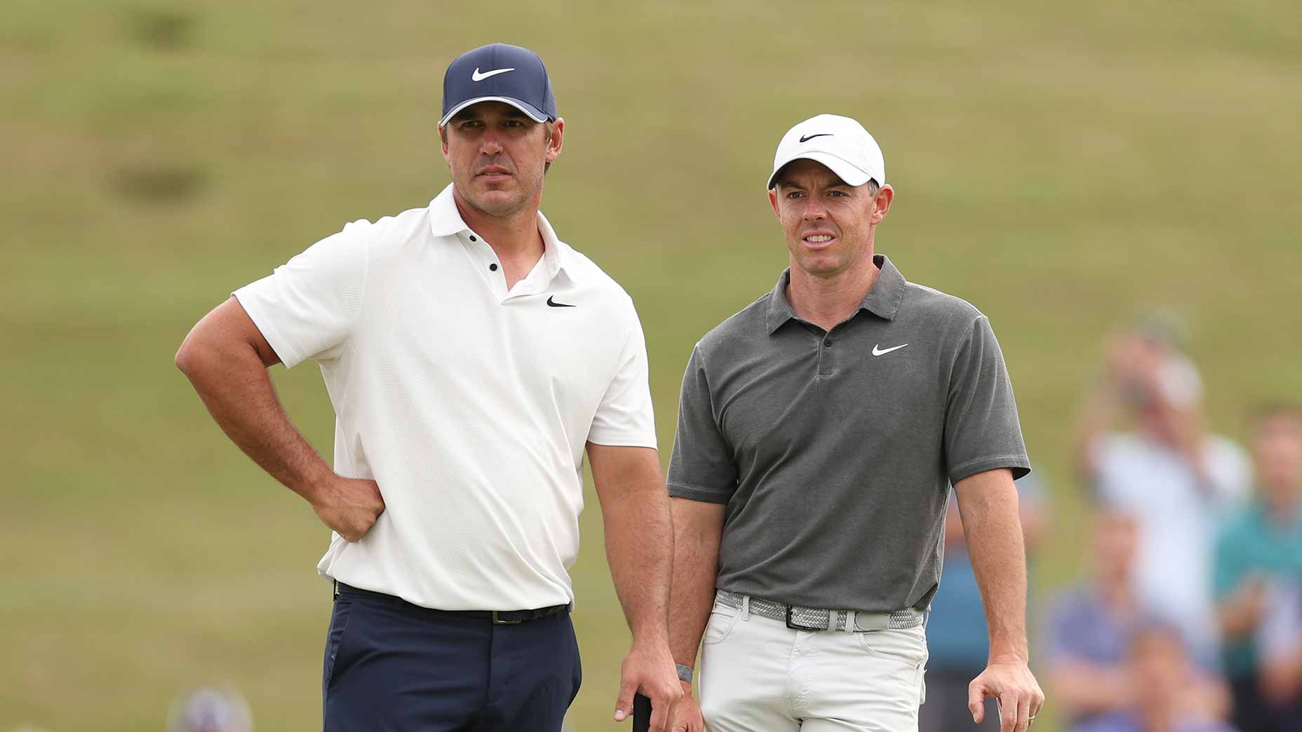 brooks koepka in cream shirt and rory mcilroy in grey shirt stand at us open