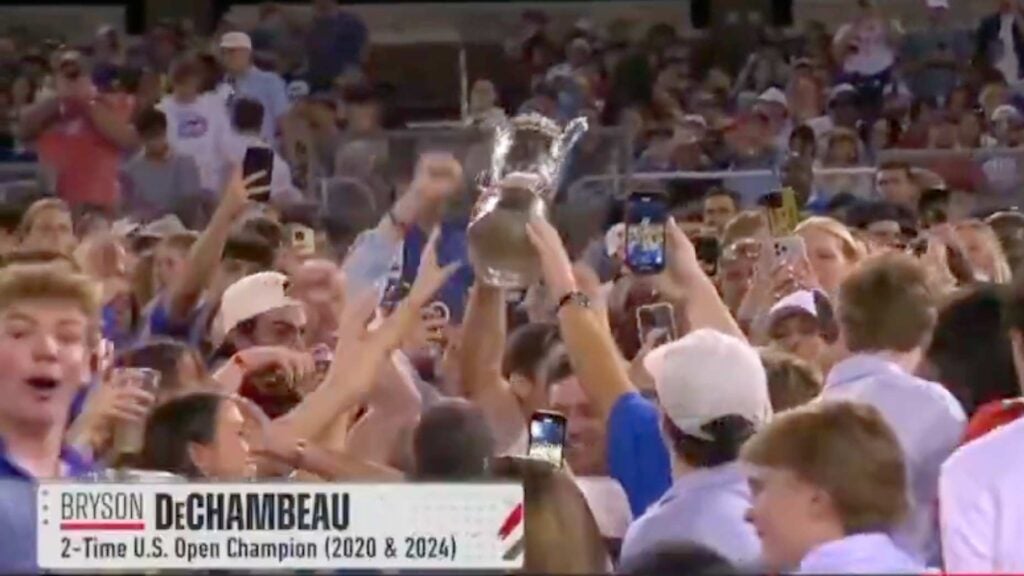 Fans hold the U.S. Open golf trophy at SMU football game.