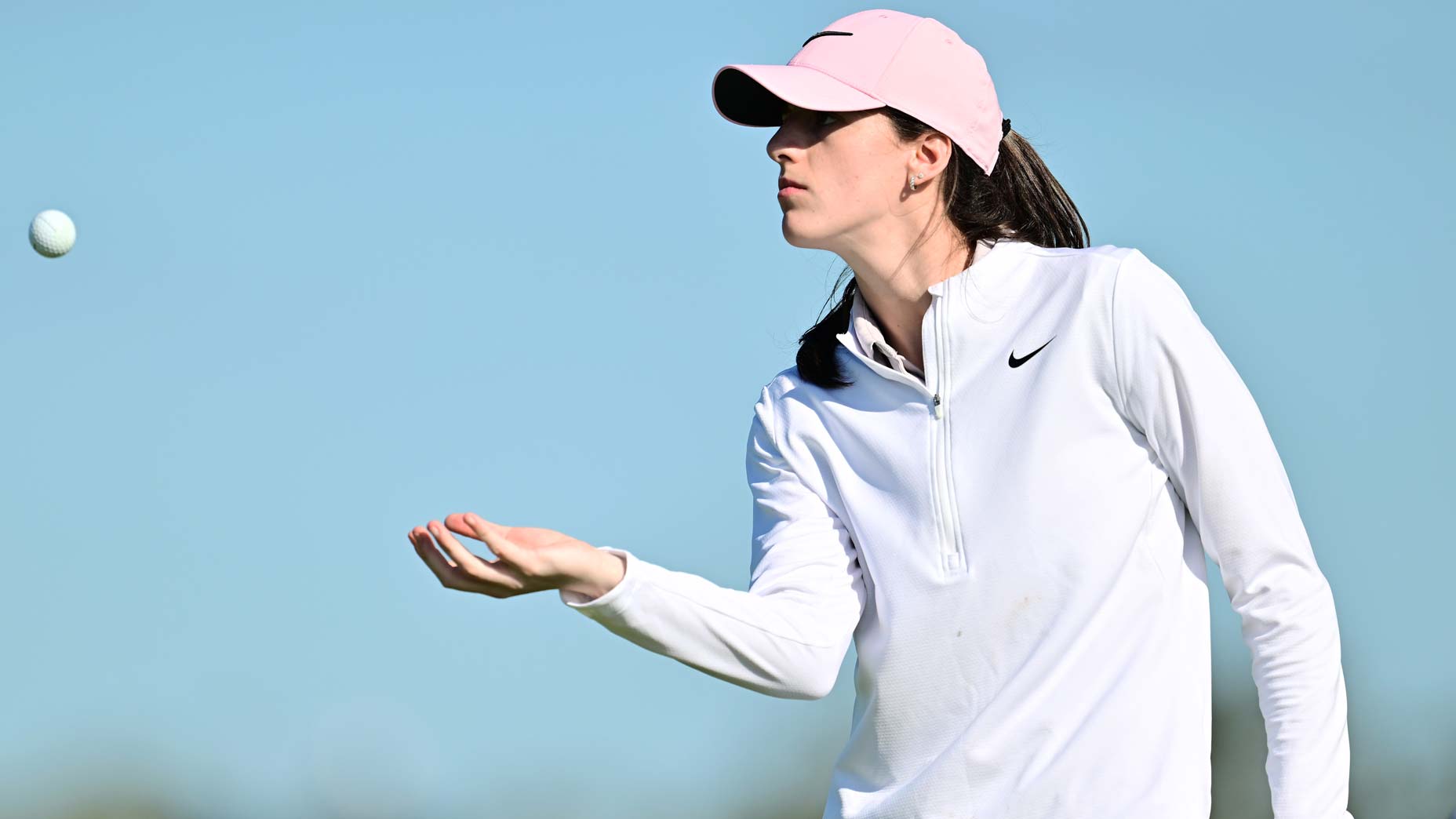 WNBA star Caitlin Clark looks to hit the ball on the 11th green before ANNIKA Gainbridge drives at Pelican 2024 at Pelican Golf Club.