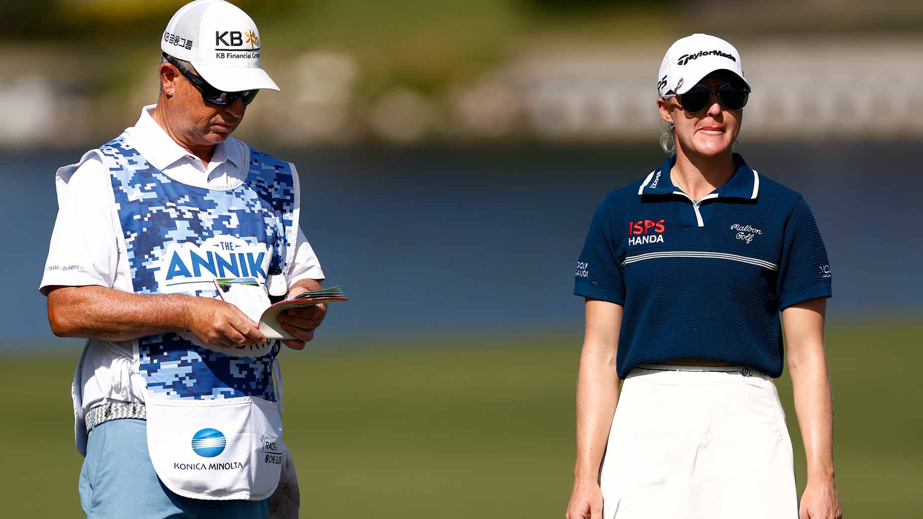 charley hull stands next to his caddy on the golf course