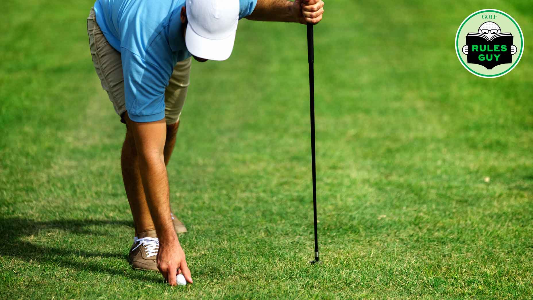 Golfer places ball on tee preparing for a driver shot.