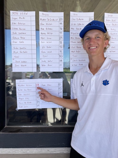 Maddox Nielson poses by the leaderboard after shooting 59.