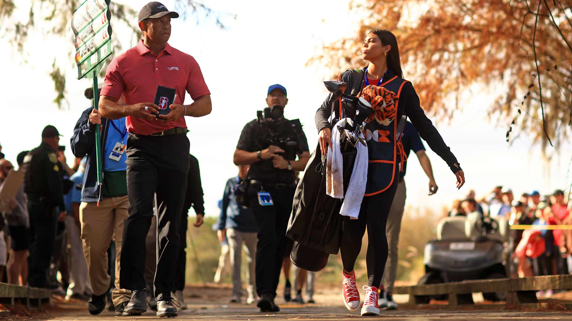 Tiger Woods walks to the next tee with daughter Sam caddying for him.