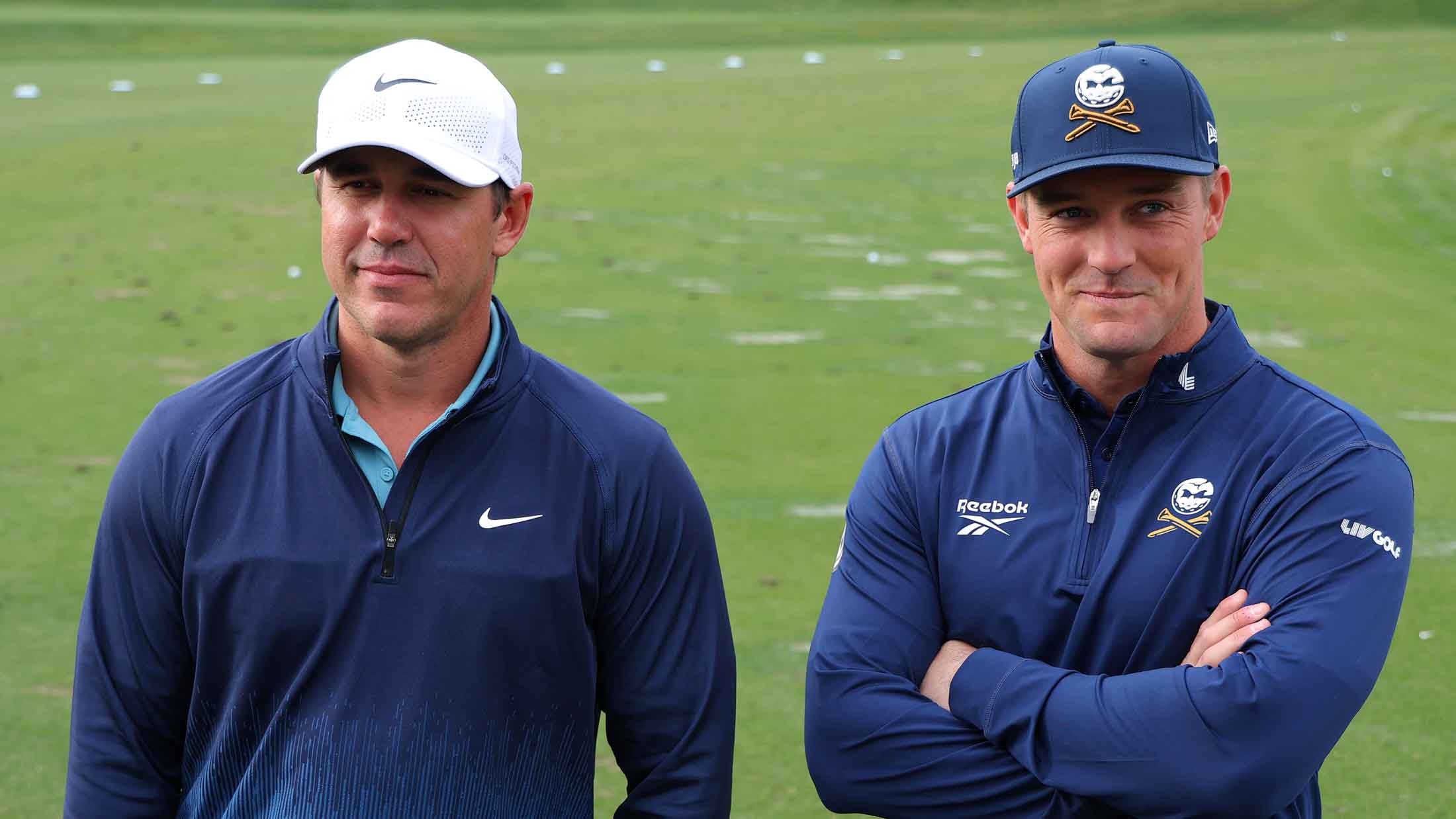 Brooks Koepka (L) and Bryson DeChambeau of LIV Golf watch before the Showdown: McIlroy and Scheffler v DeChambeau and Koepka at Shadow Creek Golf Course