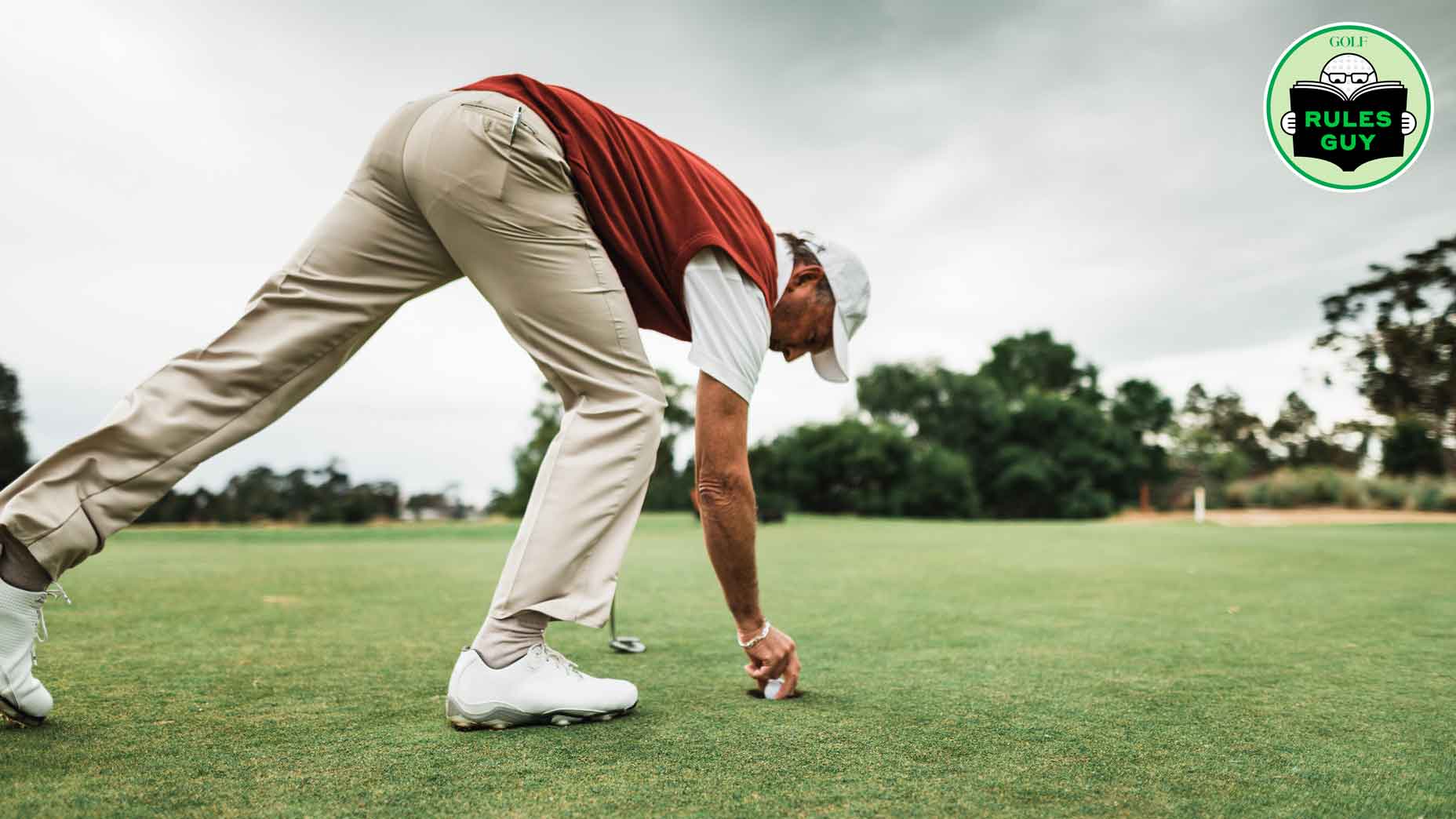 golfer removing golf ball from hole