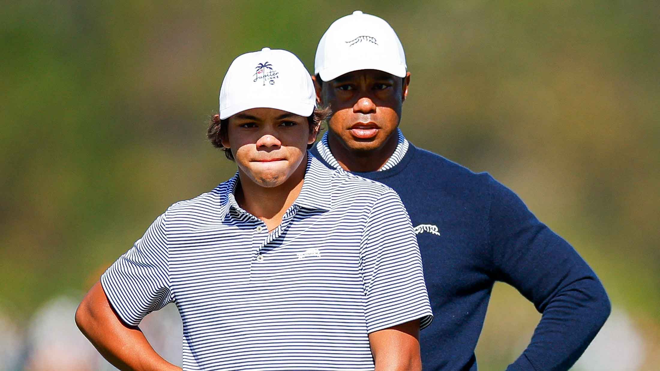 Tiger Woods and his son Charlie Woods look over a putt on the fifth hole during the first round of the PNC Championship at Ritz-Carlton Golf Club