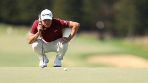 Collin Morikawa reads a putt while putting during a PGA Tour event.