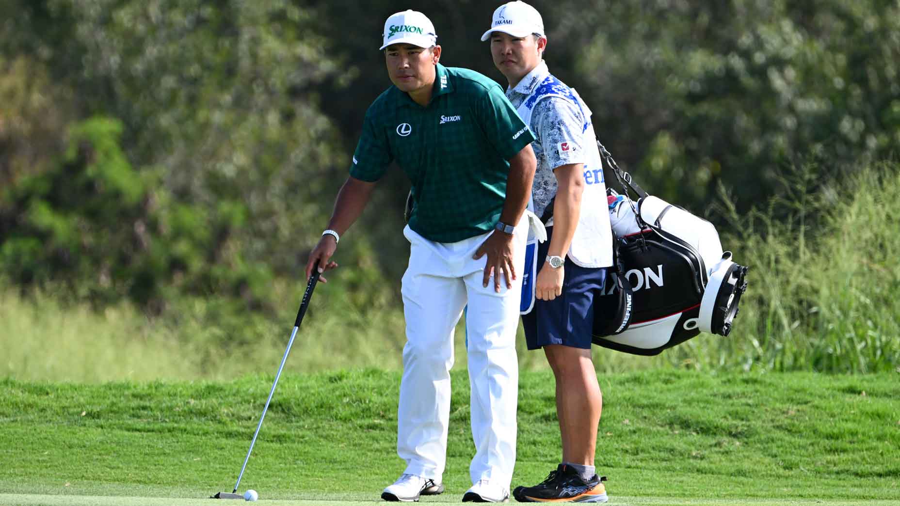 Hideki Matsuyama of Japan with his caddie Shota Hayafuji look over the putt at the 18th green during the third round of The Sentry at The Plantation Course at Kapalua on January 4, 2025 in Kapalua, Maui, Hawaii.