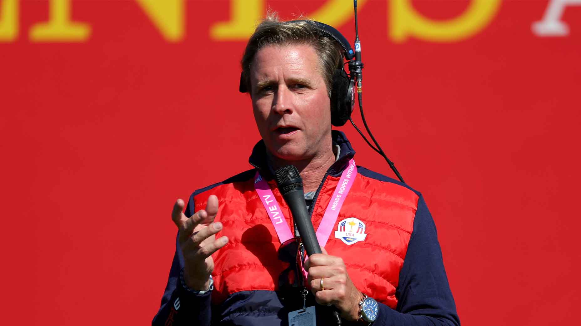 gary williams speaks into microphone at the ryder cup in red ryder cup shirt