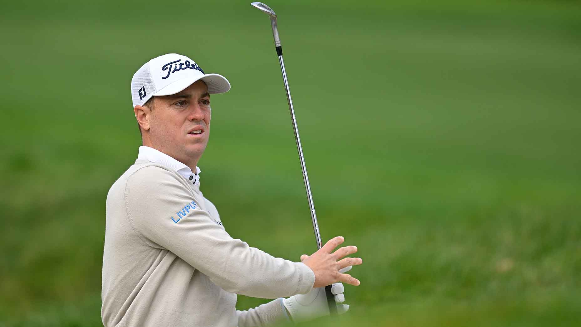 justin thomas swings wedge in cream sweater at the AT&T Pebble Beach Pro-Am.