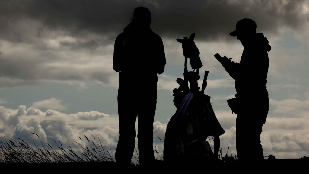 Silhouette of a golfer and her caddie waits on the tee box during the practice round ahead of the AIG Women's Open on day two at St Andrews Old Course