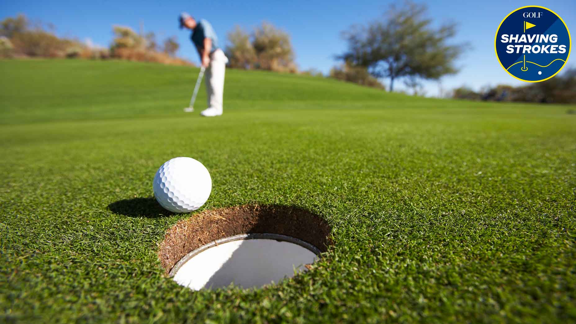 golf ball on the edge of a cup on a green