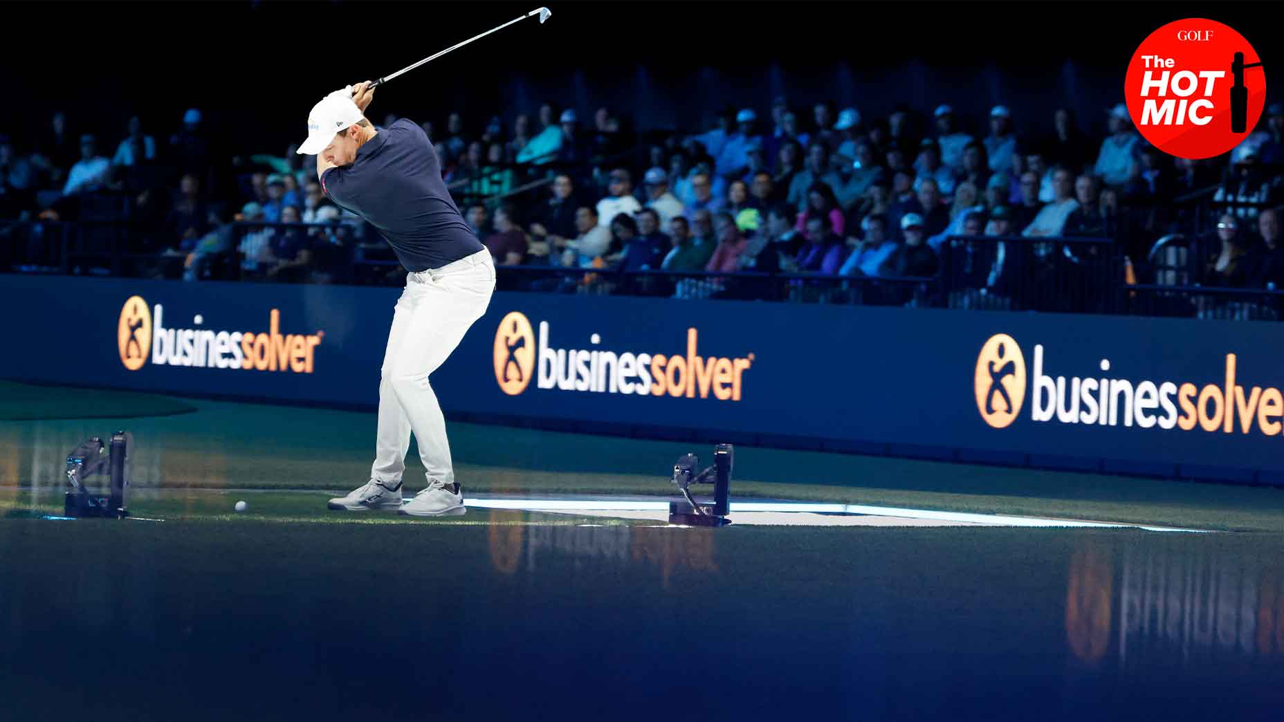 Matt Fitzpatrick swings golf club at the TGL's arena in navy shirt and white hat