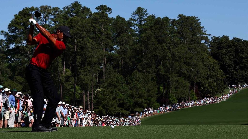 tiger woods swings driver at augusta national during the Masters in red shirt and black pants