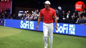 tiger woods laughs in red shirt and white hat at TGL debut at Sofi Center in West Palm, Florida.