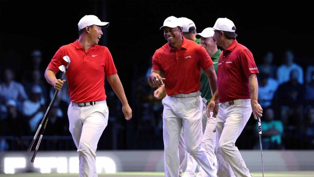 Tiger Woods, Kevin Kisner, and Tom Kim interact after a hole during their TGL match on Monday.