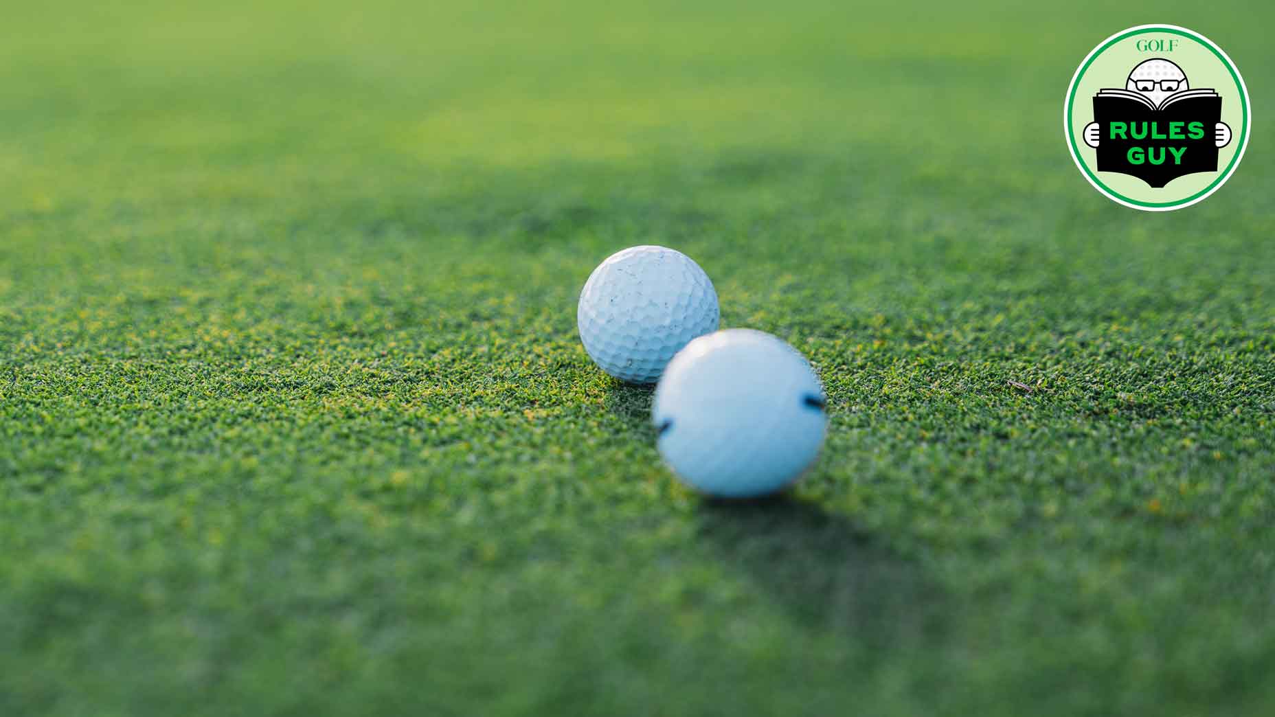 two golf balls next to each other on a green