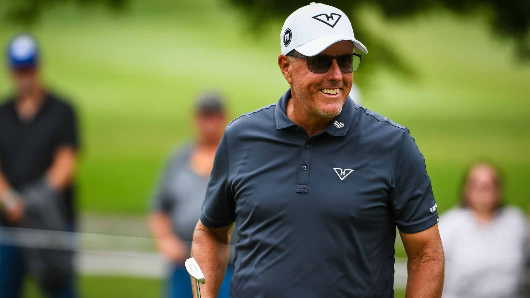 Phil Mickelson smiles after making a putt at LIV Golf Greenbrier.