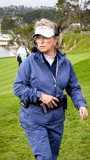 dottie pepper holds a yardage book at the AT&T Pebble Beach Pro-Am in blue rain suit.