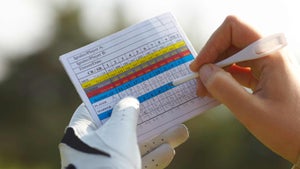 A golfer records his golf scoring using a golf scorecard.