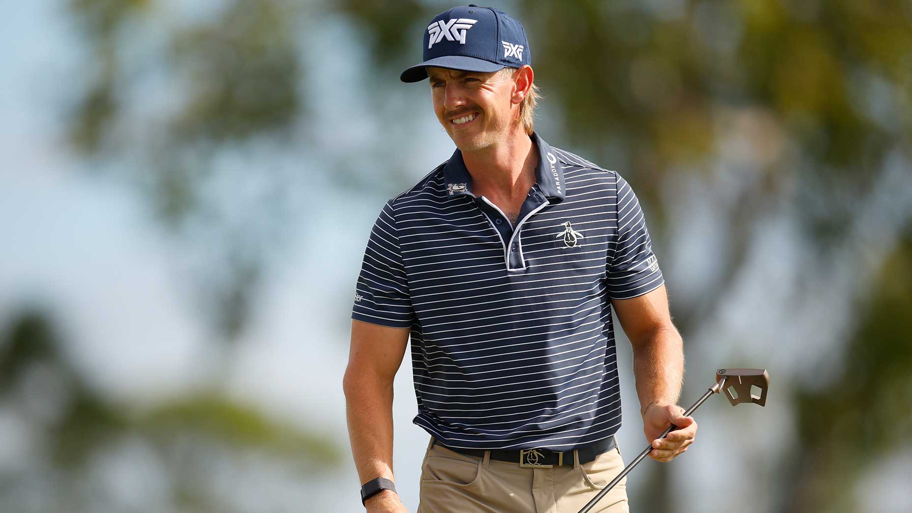 Jake Knapp smiles at Conongnizant Classic in a blue navy shirt and a blue hat