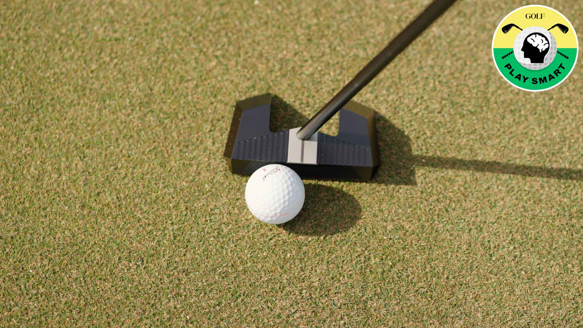 ball in front of putterhead on the ground