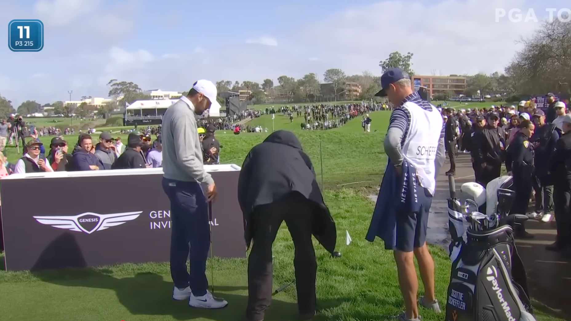 Scottie Scheffler discusses his lies on the 11th hole of Torrey Pines with Rules officials and his caddies.