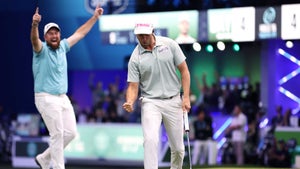 wyndham clark pumps fist in TGL uniform alongside Shane Lowry raising hands in the air in blue shirt at TGL match