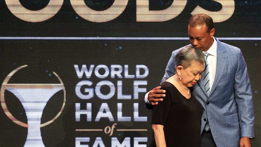 tiger woods embraces with mother tida woods in blue suit and black dress at hall of fame induction ceremony.