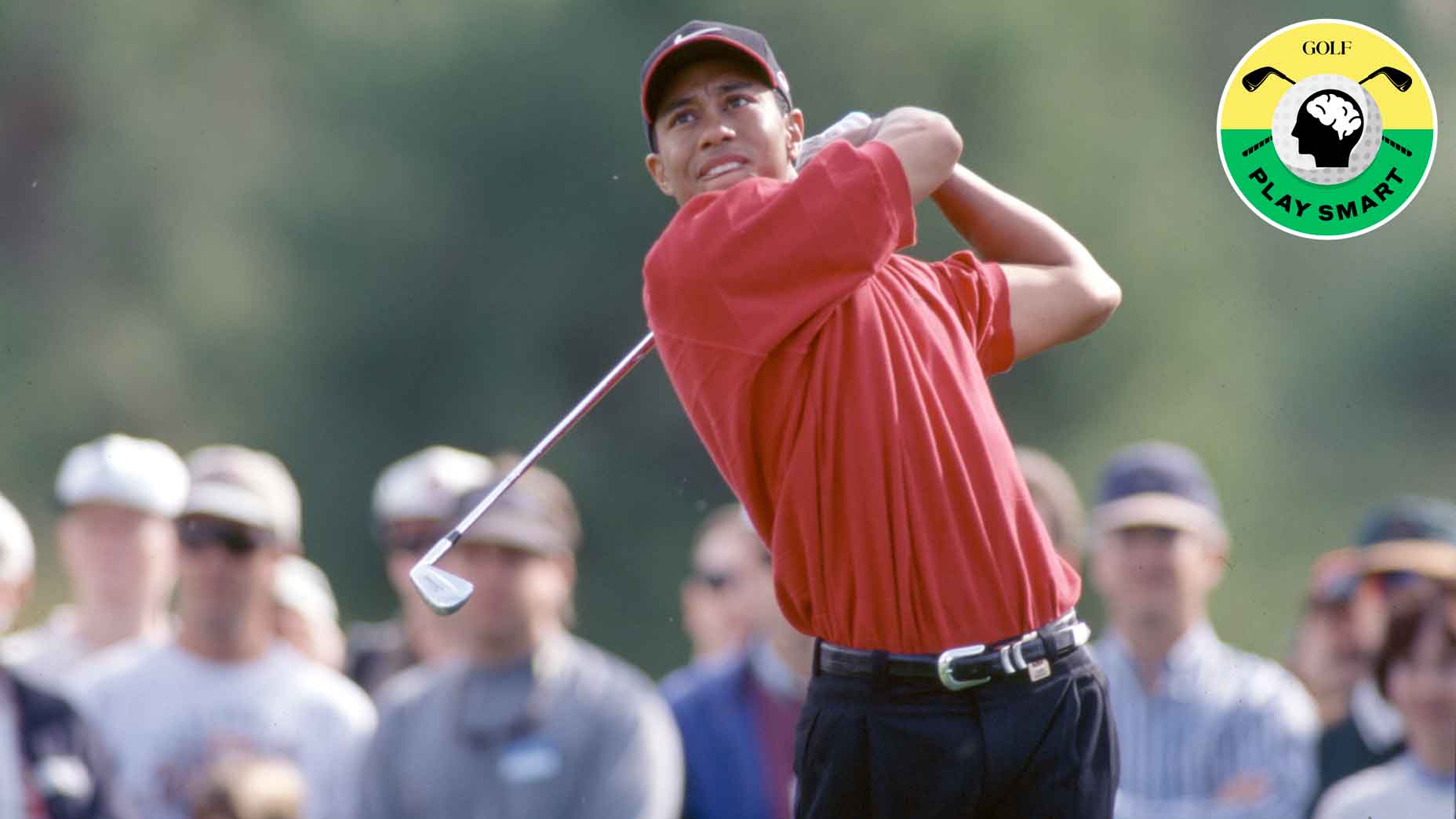 tiger woods swings iron wearing red shirt and black pants