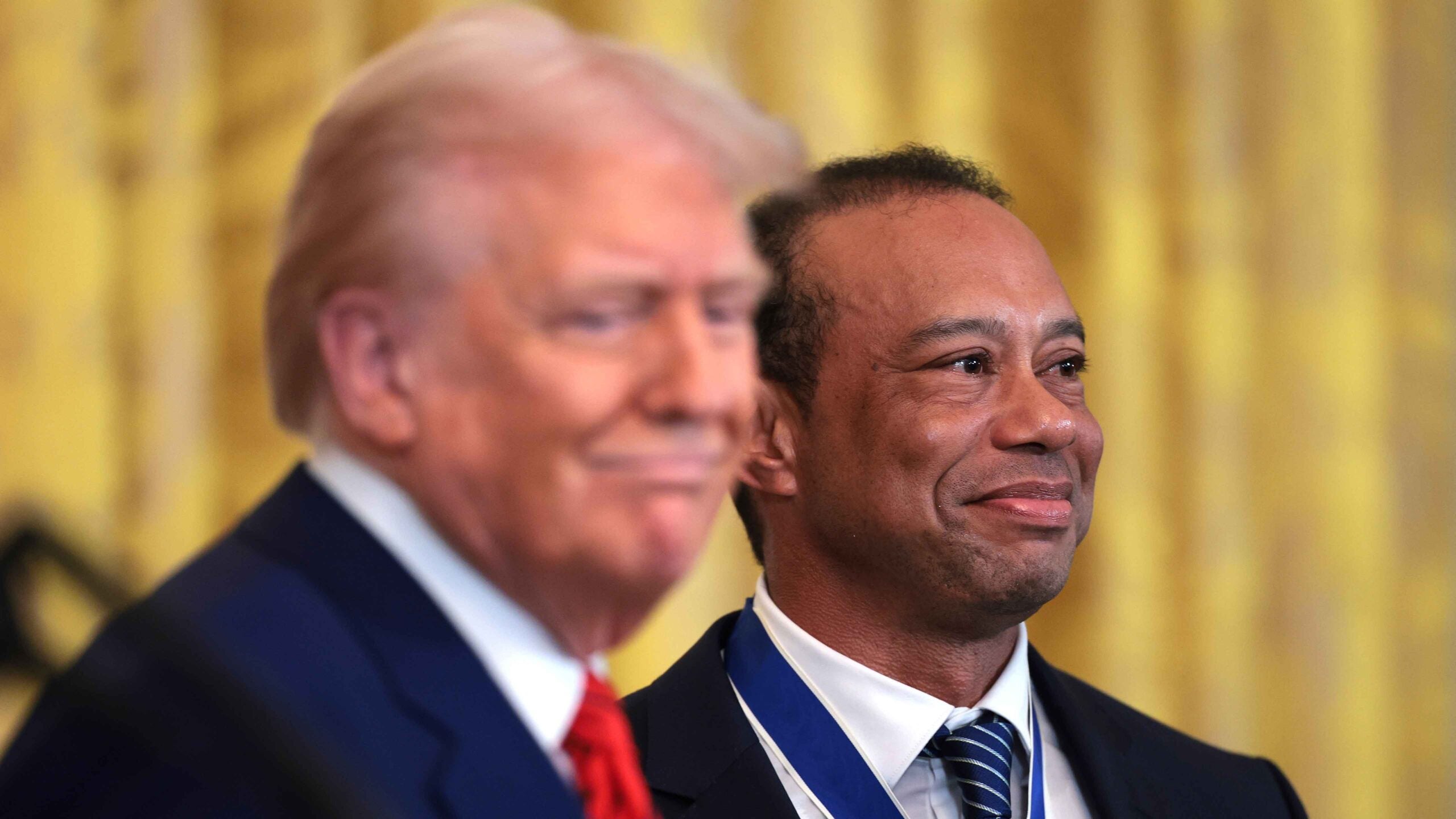 Tiger Woods stands alongside US President Donald Trump during a reception to honor the black history month in the White House Eastern House