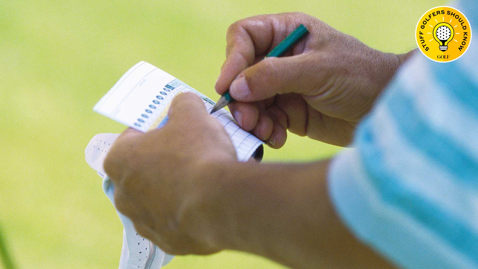 a golfer marks a scorecard