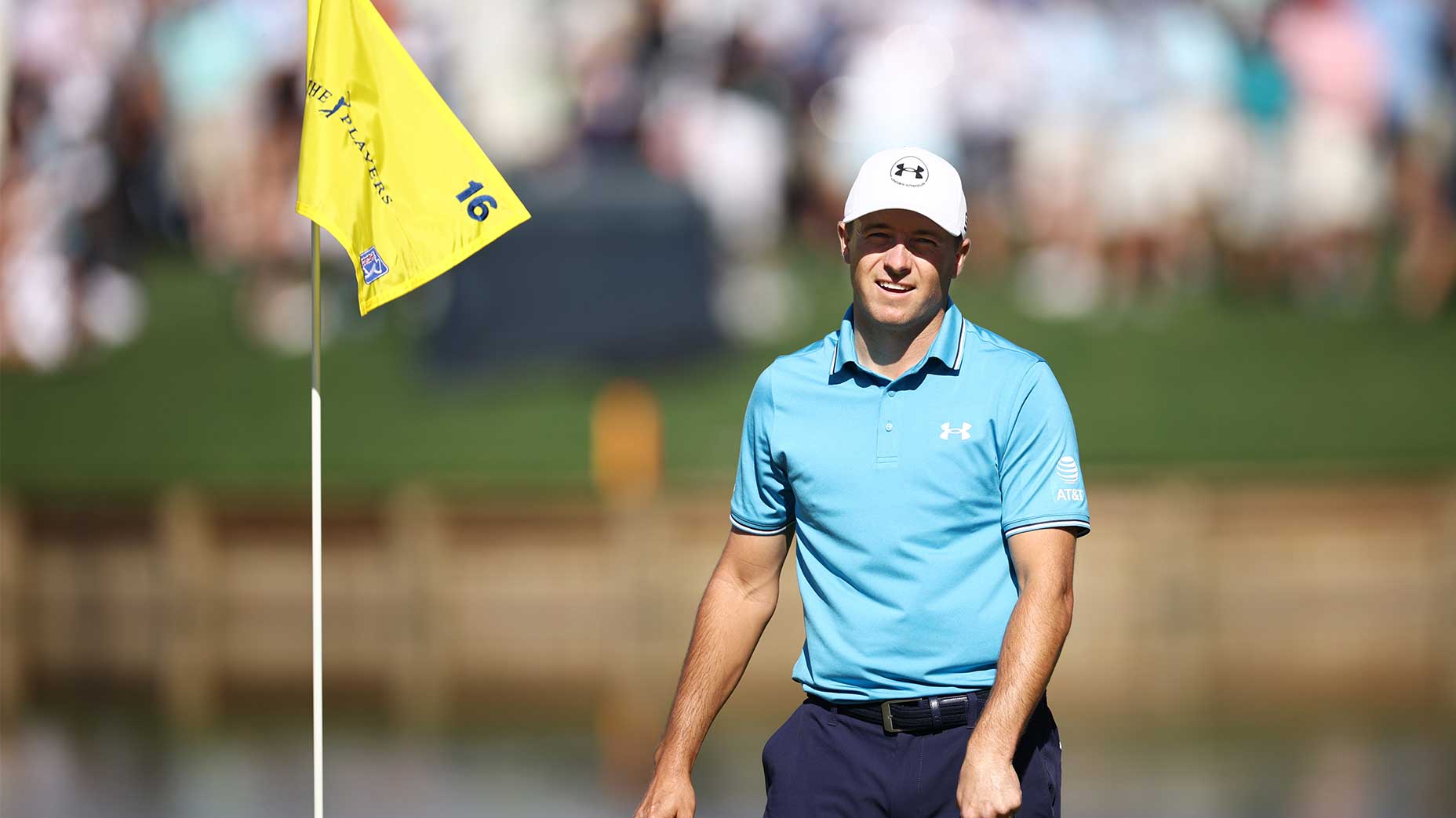 Jordan Spieth grimaces at the Players Championship in a blue shirt and navy pants