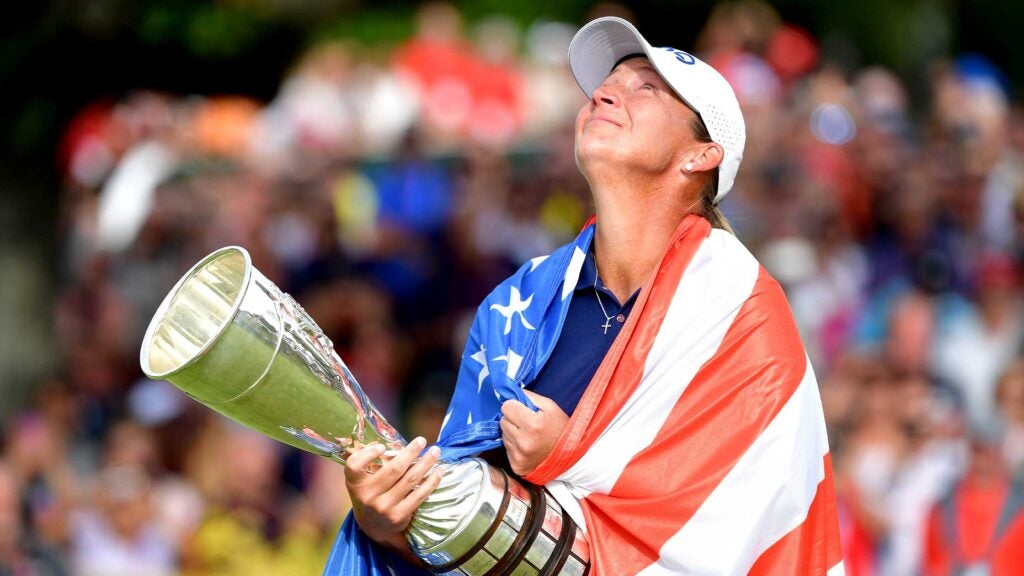 angela stanford stares up in joy while holding evian championship trophy and wrapped in american flag