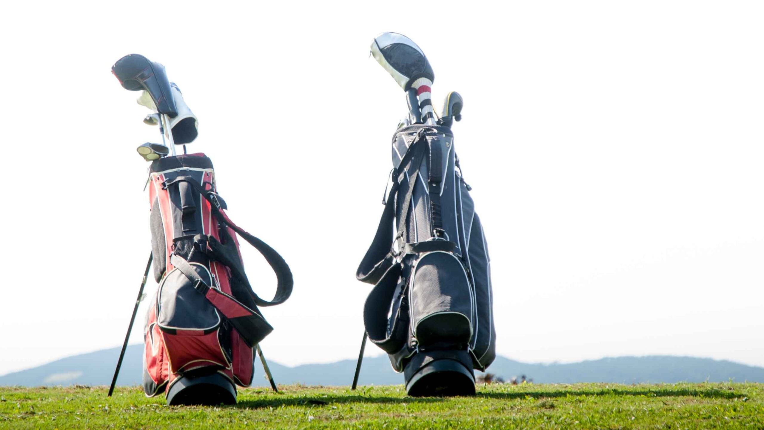 two golf bags on driving range