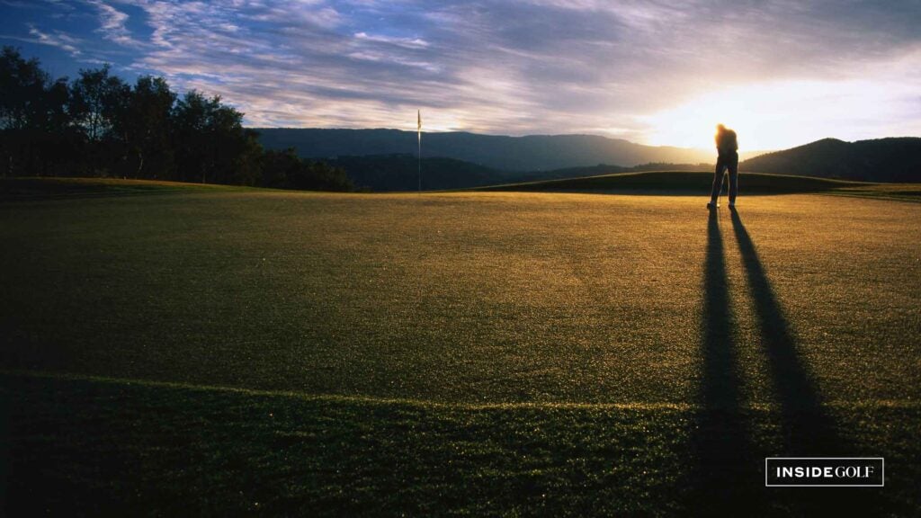 golfer putting at sunset