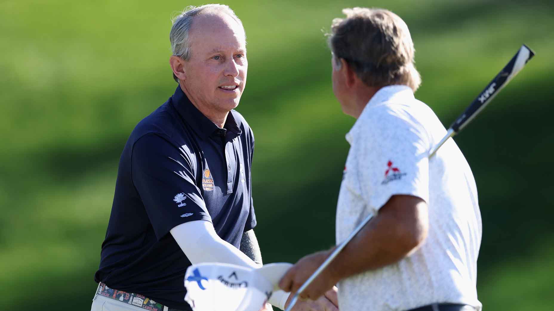 jason caron takes off hat and shakes hands with playing partner