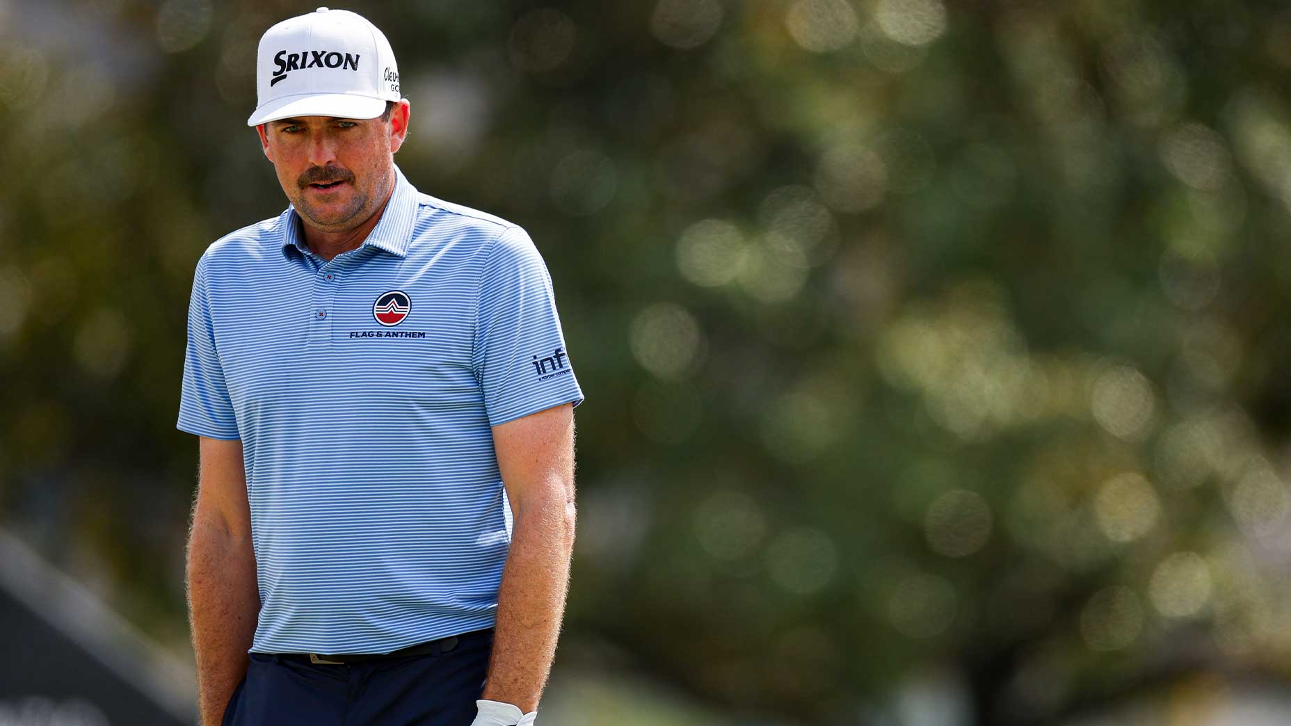 Keegan Bradley in a blue shirt and a white hat with black pants at the Arnold Palmer Demotational.