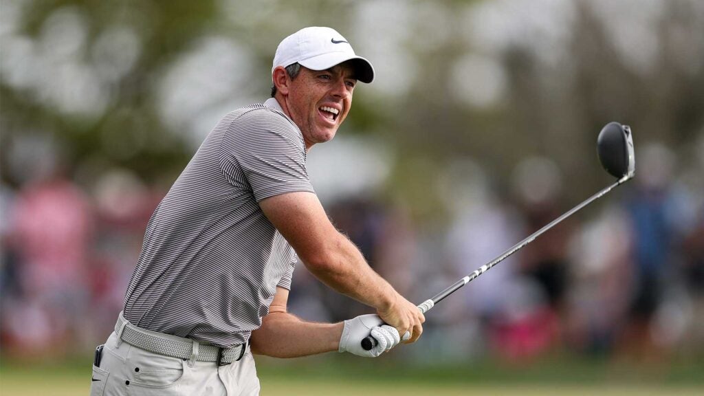 rory mcilroy grimaces while he swings driver in grey shirt and white hat at Arnold Palmer Invitational.