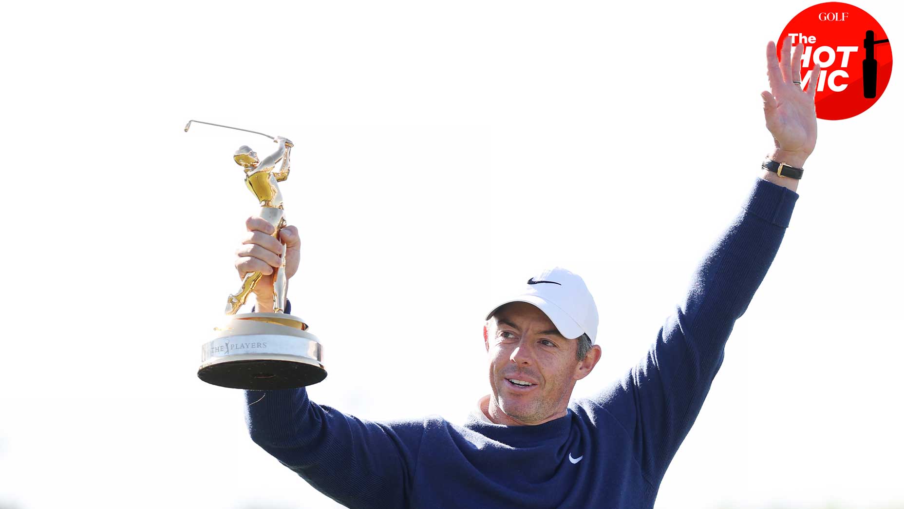 Rory Mcilroy raises the player championship trophy in the Navy Triko and White Caps