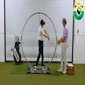 golf teacher instructs student with training aid